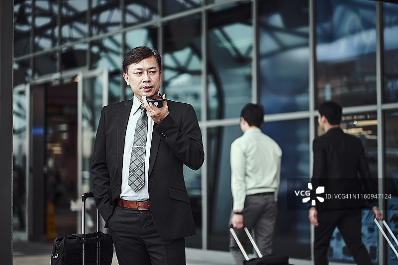 自信的男经理在户外用手机交谈图片素材