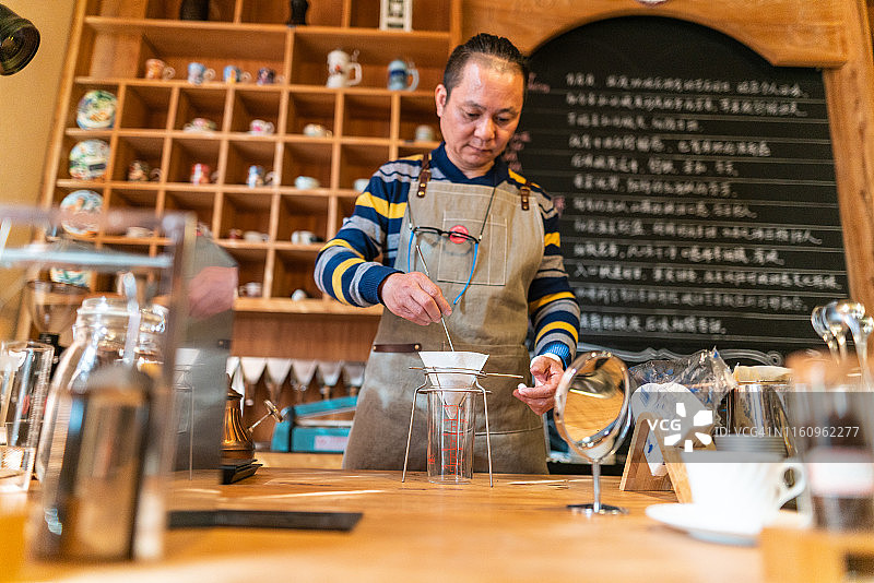亚洲咖啡店主正在准备新鲜咖啡图片素材