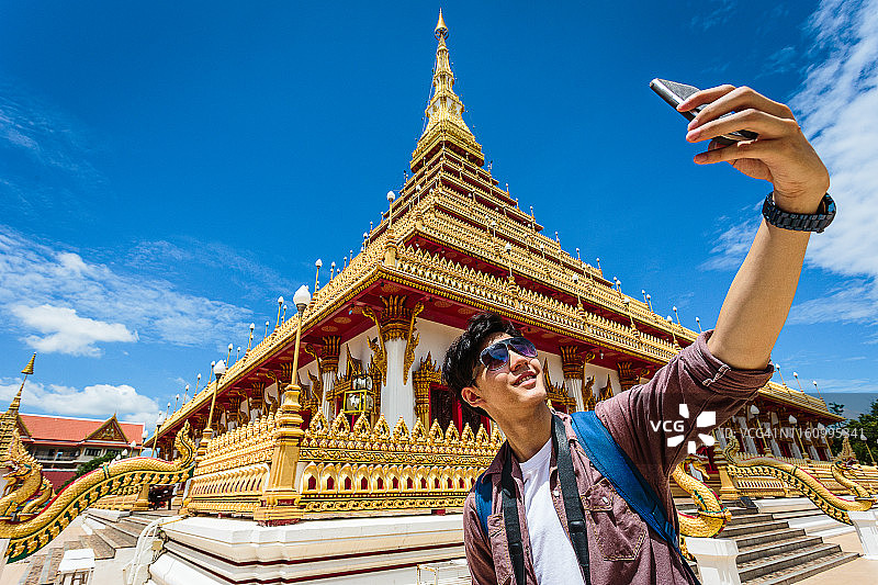 在泰国孔敬府农瓦寺用手机自拍的亚洲男游客图片素材