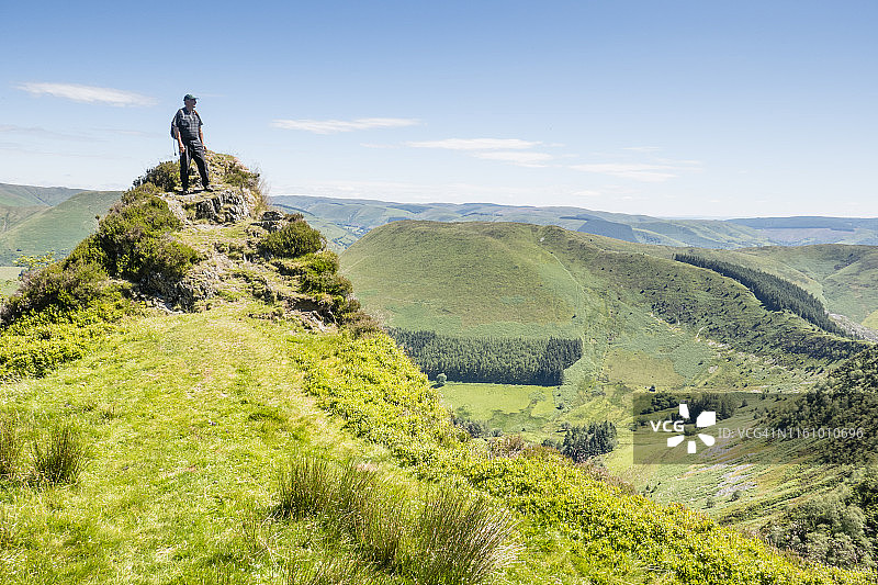 男人在克雷格·梅斯盖尔斯最高点欣赏风景；图片摄于英国威尔士迪纳斯·莫德威和布尔赫·林恩·巴赫之间的寒武纪之路，七月图片素材