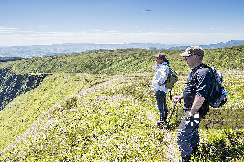 两名中年白人男性背包客在英国威尔士 Dinas Mawddwy 和 Bwlch Llyn Bach 之间的 Cambrian Way 观看山谷景色图片素材