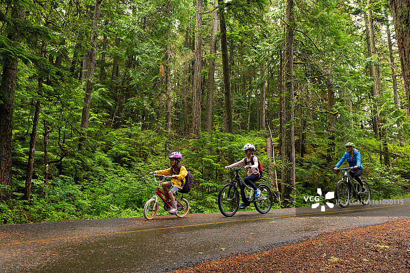 女人带女儿森林中骑行图片素材