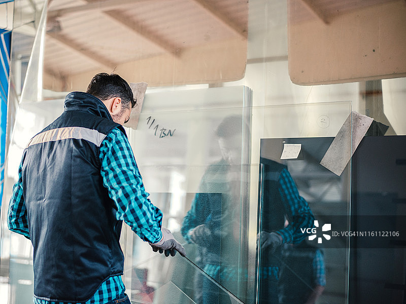 工人在仓库里搬运玻璃板图片素材