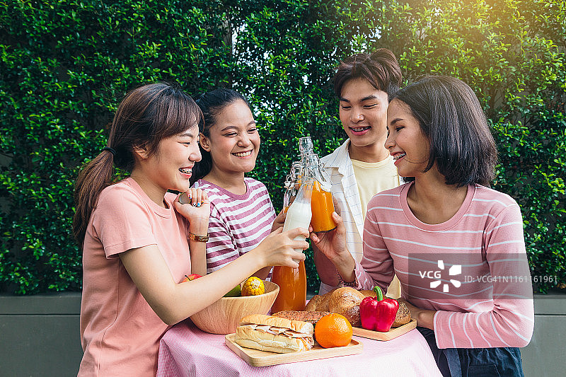 一群快乐的亚洲朋友在户外公园野餐，健康食品和生活方式概念图片素材