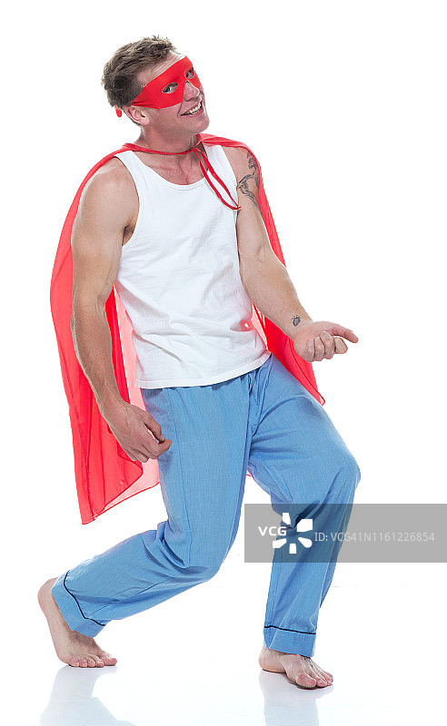 穿着睡衣和超人披风，弹奏空气吉他的男人图片素材