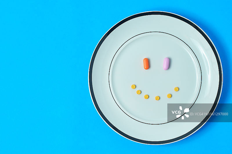 药丸、刀和绿色蔬菜在砧板上图片素材