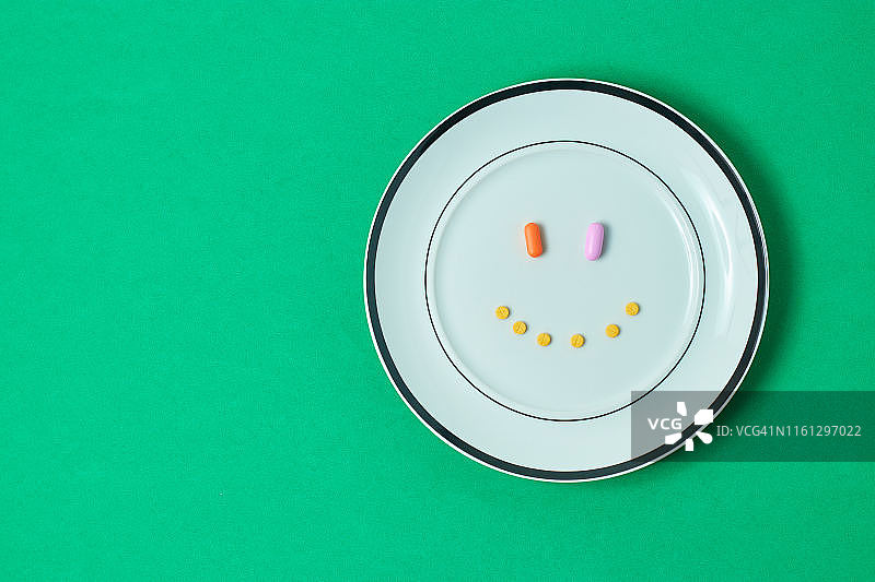 药丸、刀和绿色蔬菜在砧板上图片素材