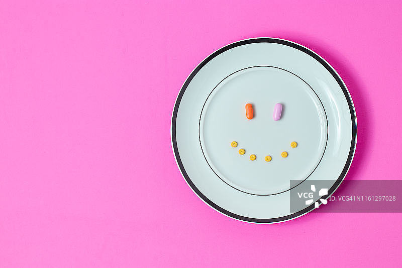 药丸、刀和绿色蔬菜在砧板上图片素材