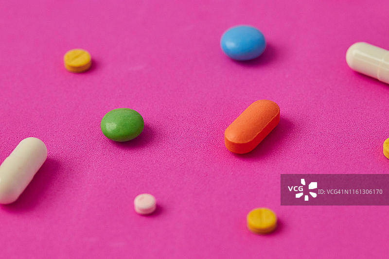 彩色背景上的药丸、胶囊和药片图片素材