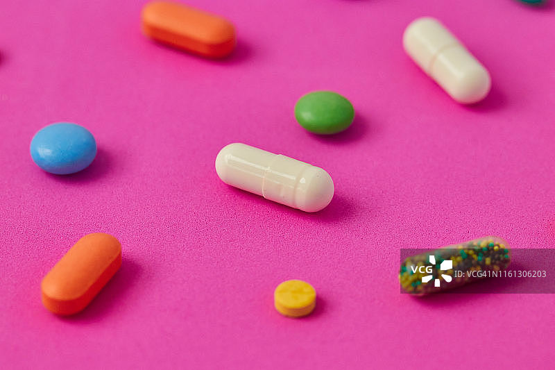 彩色背景上的药丸、胶囊和药片图片素材