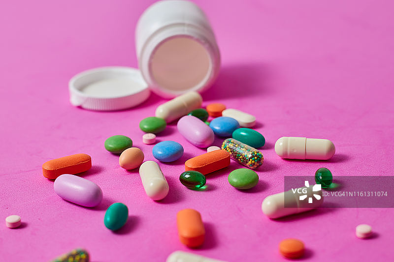 彩色背景上的药丸、胶囊和药片图片素材
