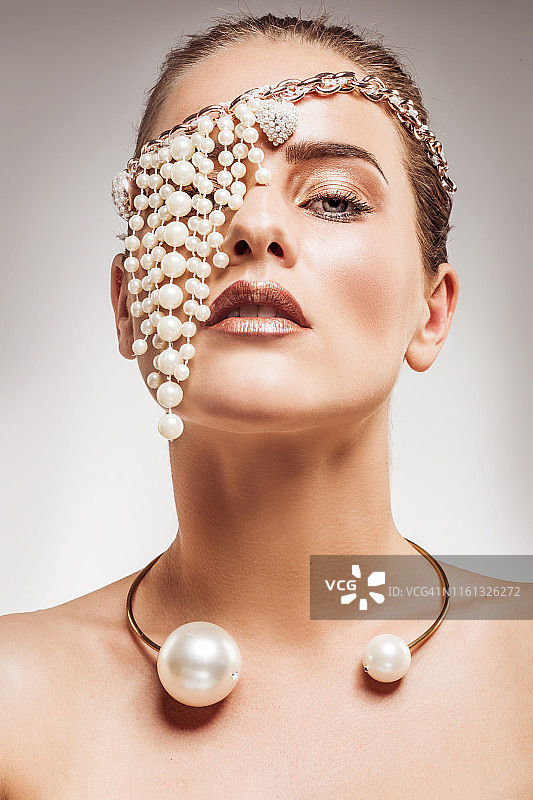 在影棚里佩戴珍珠首饰的美丽女人图片素材