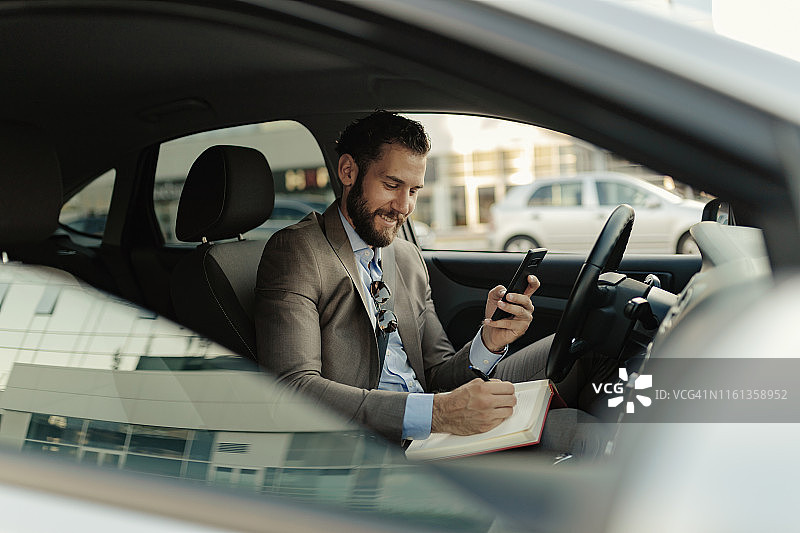 在车里写笔记的商人图片素材
