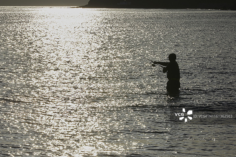 海钓者在英国南德文郡班瑟姆抛线图片素材