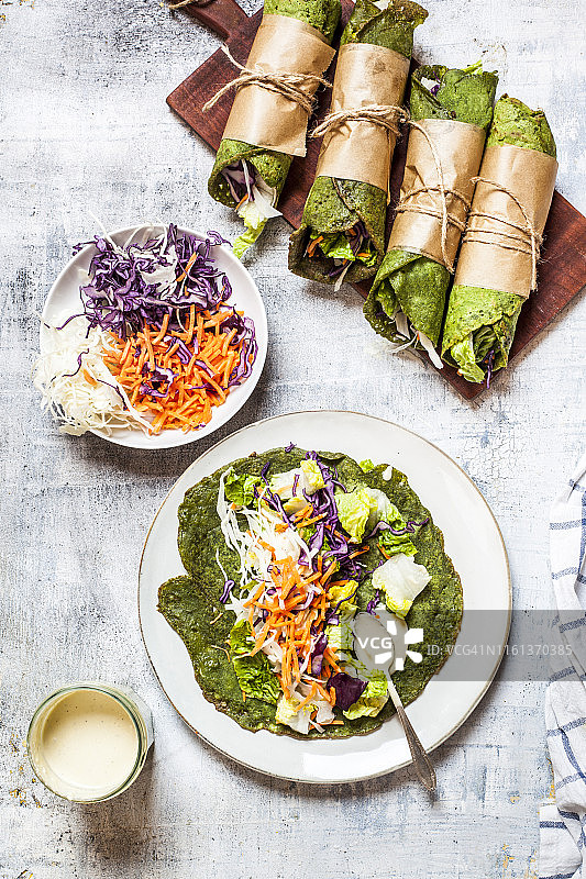 生菜卷配菠菜玉米饼，内馅包括生菜、胡萝卜和沙拉酱图片素材
