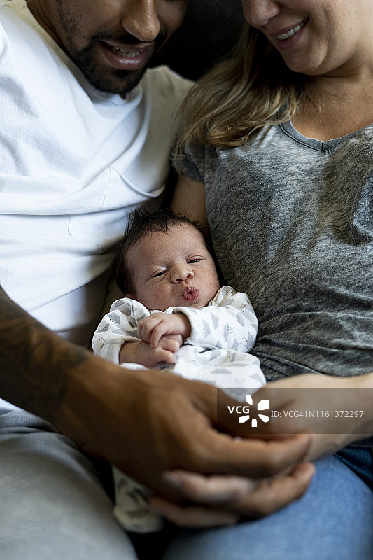 父母怀抱中的新生儿肖像图片素材