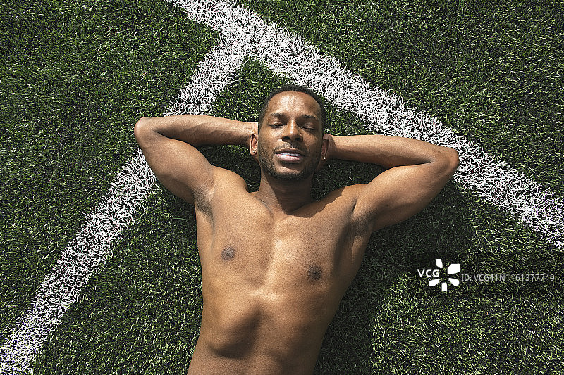 运动员在草坪上锻炼后放松图片素材