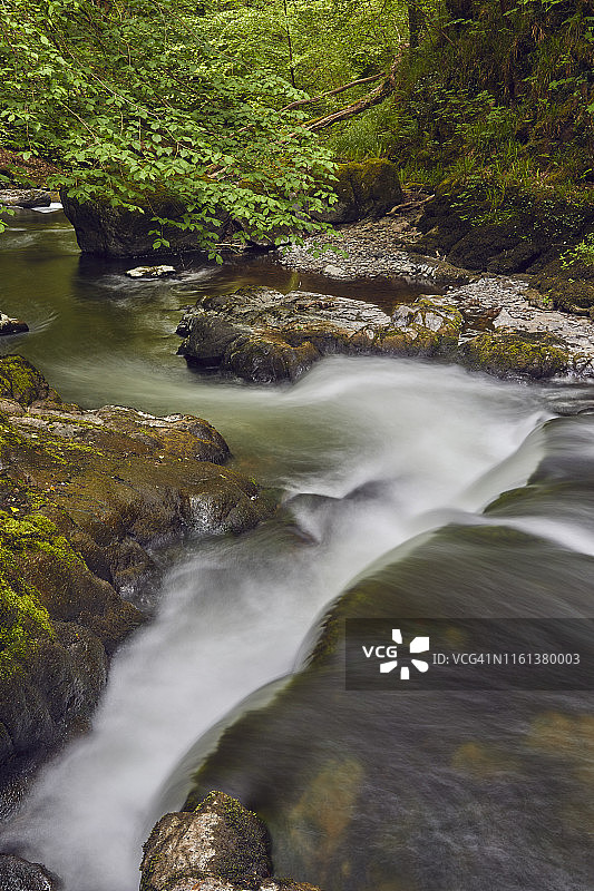 河流流经古老的林地：英国德文郡埃克斯穆尔国家公园沃特斯米特地区的东林河图片素材