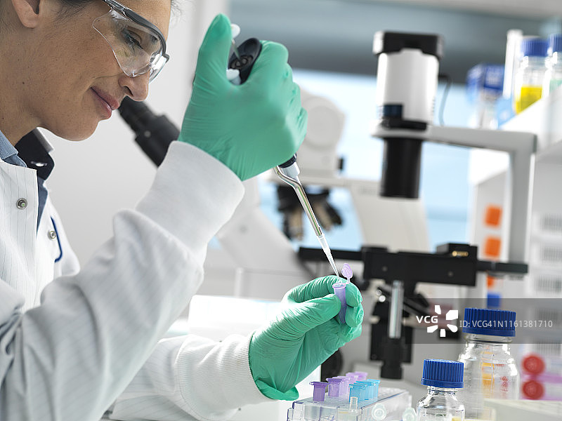 生物技术研究：科学家在实验室实验中将样品滴入小瓶中准备进行分析图片素材