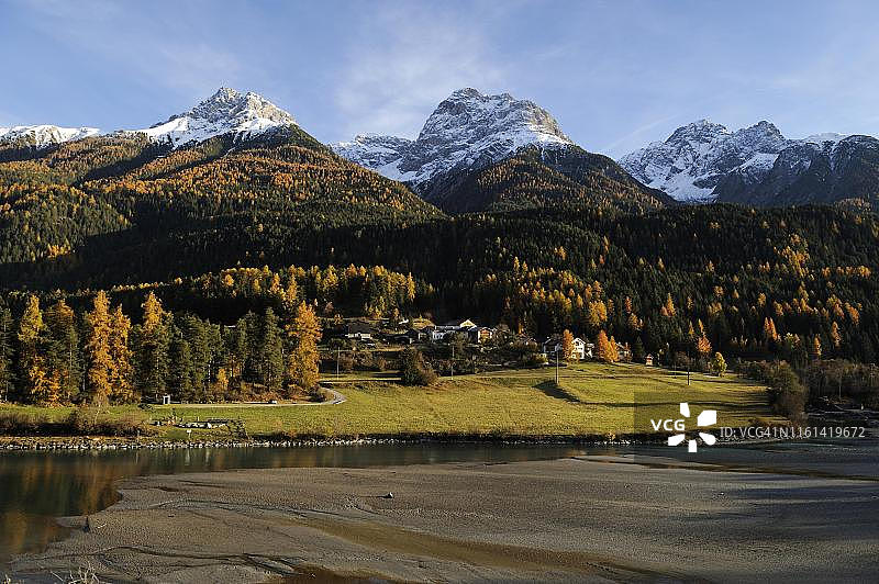 瑞士格里松州下恩加丁地区，斯科尔，被秋色落叶松森林和雪山环绕的因河图片素材