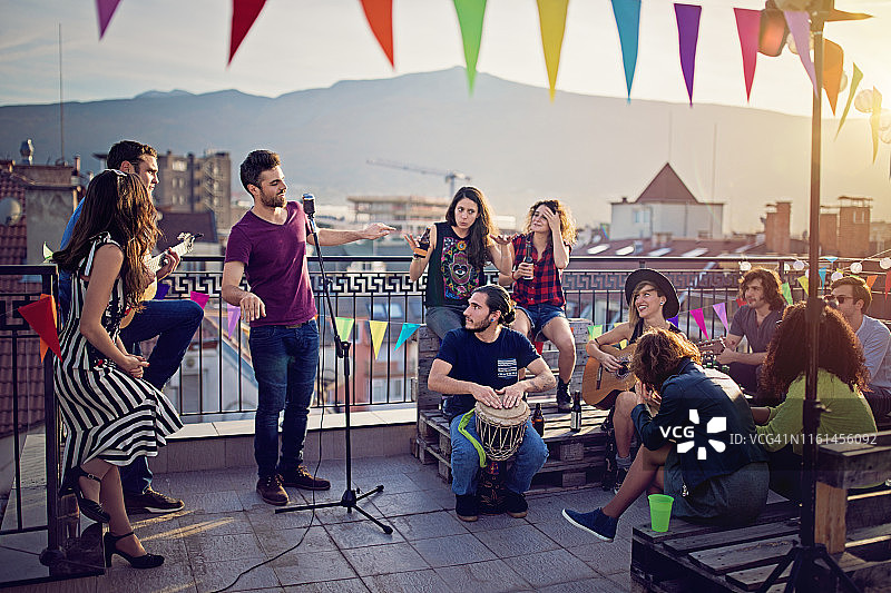 朋友们在屋顶露台上举办音乐会庆祝图片素材