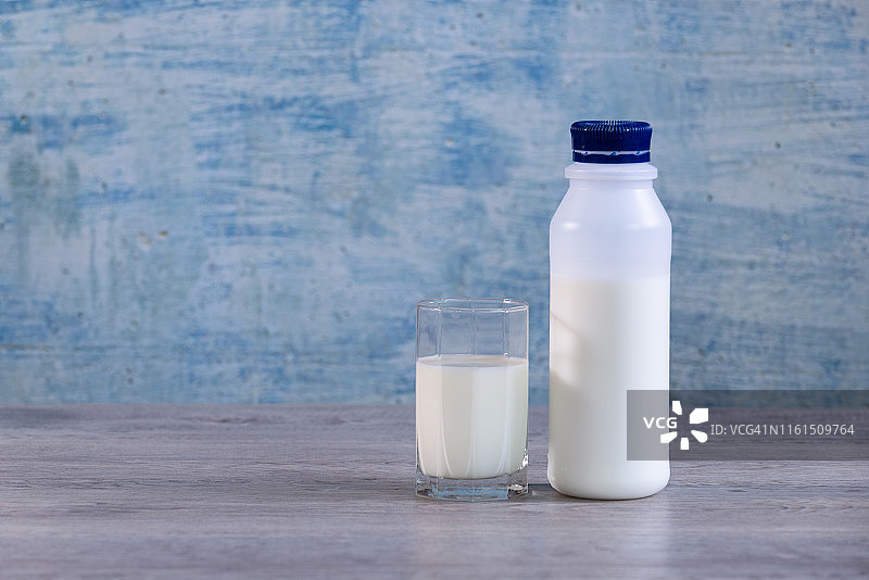桌子上的瓶装牛奶和草图片素材