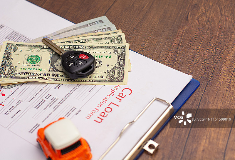 汽车钥匙和汽车模型在已签署的协议文件上图片素材