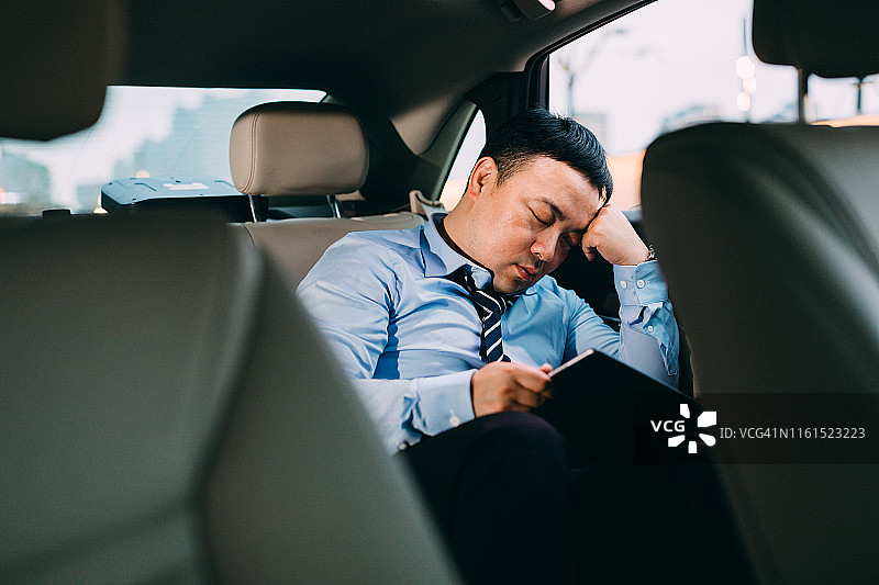 亚洲商人疲惫地坐在车里图片素材