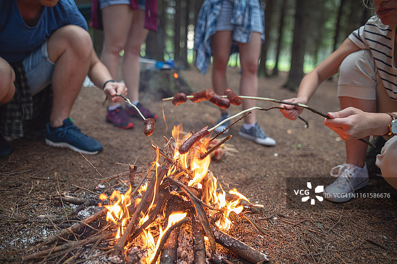 露营者在篝火上烤香肠图片素材