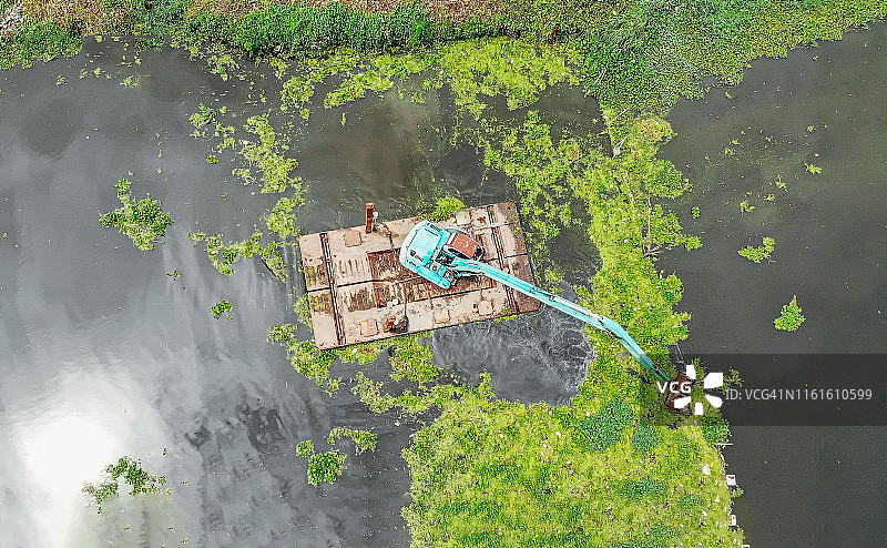 航拍：挖掘机在水中清除杂草。图片素材