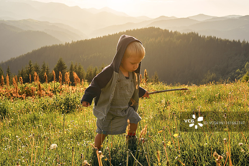 在日落时分山间空地上奔跑的快乐小女孩图片素材