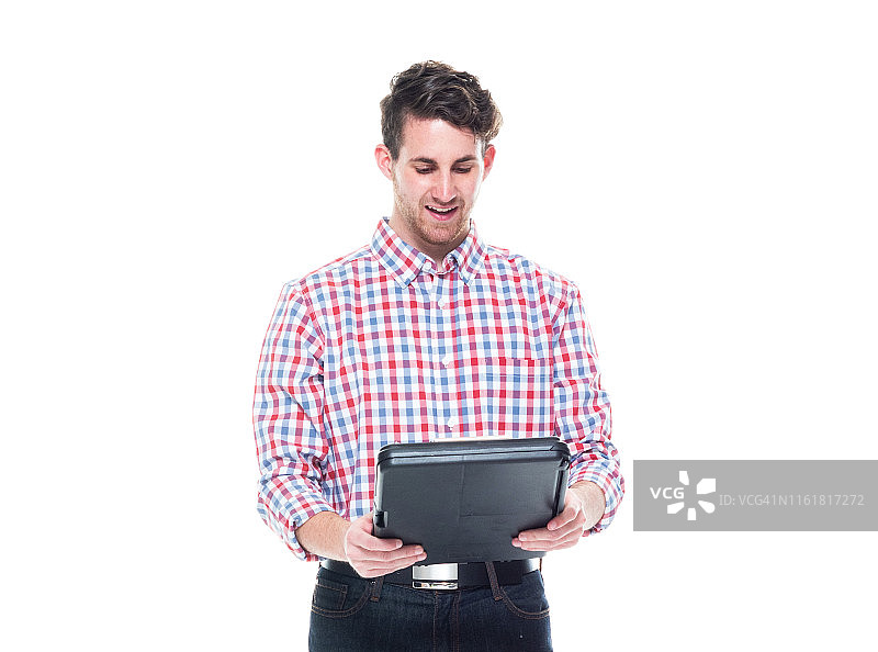 穿着格子衬衫和牛仔裤的年轻男人使用写字板图片素材