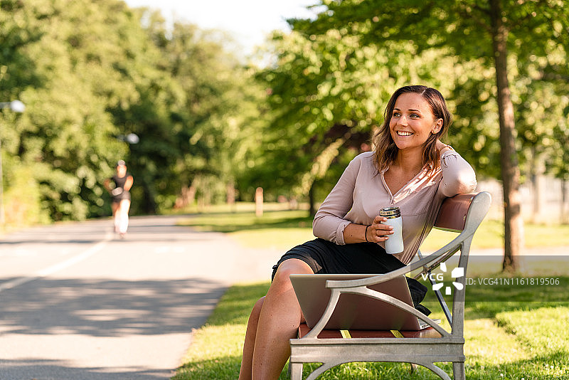 自由职业女性使用可重复使用的咖啡杯工作图片素材