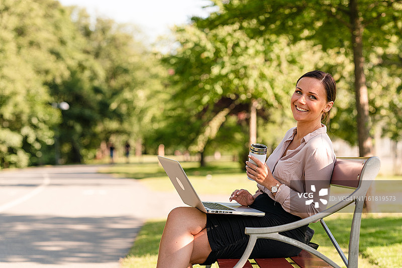 自由职业女性使用可重复使用的咖啡杯工作图片素材