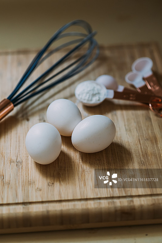 砧板上的三颗鸡蛋和烘焙用具图片素材