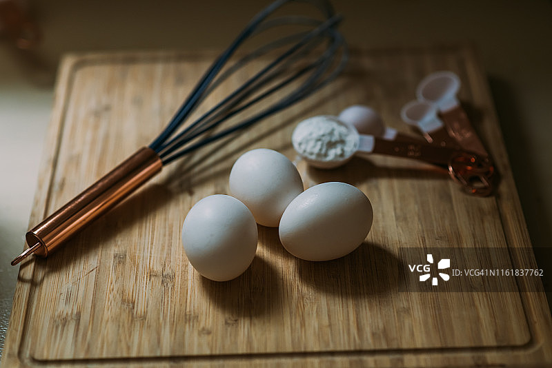 砧板上的三颗鸡蛋和烘焙用具图片素材