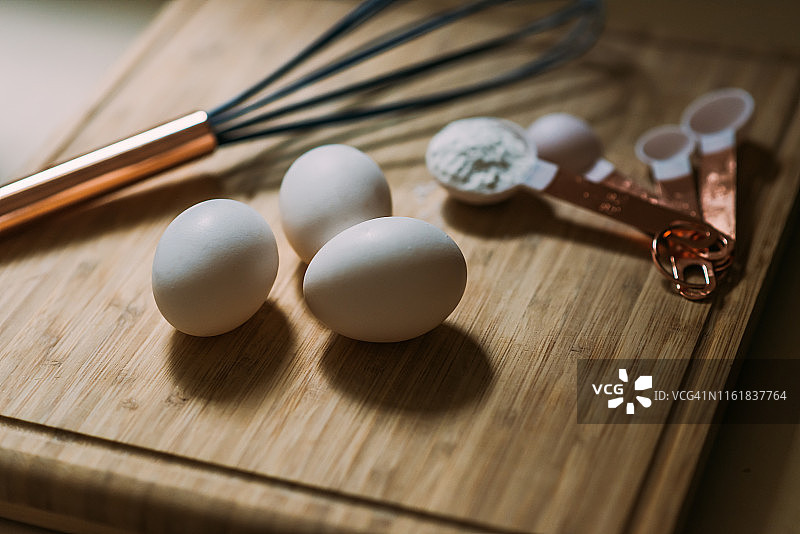 砧板上的三颗鸡蛋和烘焙用具图片素材