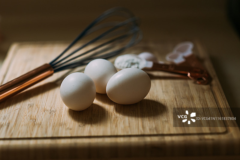 砧板上的三颗鸡蛋和烘焙用具图片素材