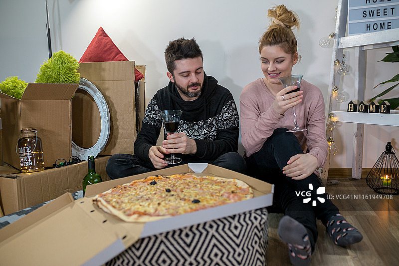 年轻情侣搬家吃披萨俯视图图片素材