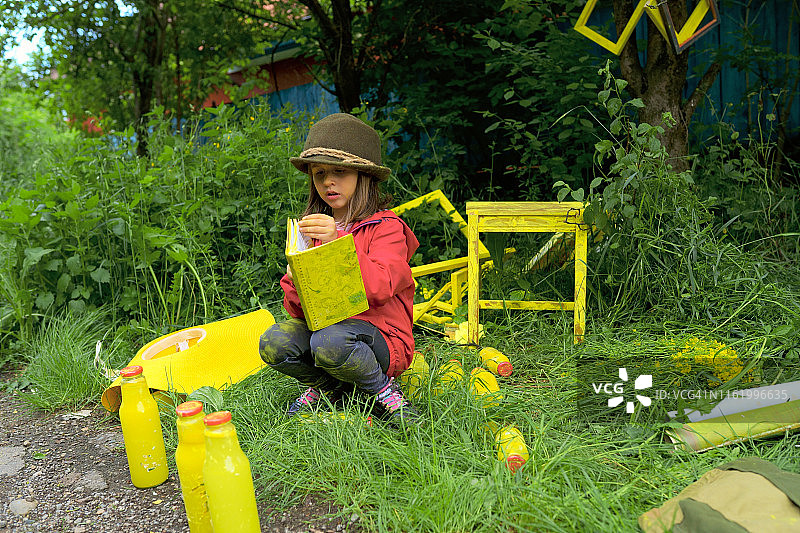 戴帽子的金发女孩在户外用水彩颜料绘画图片素材