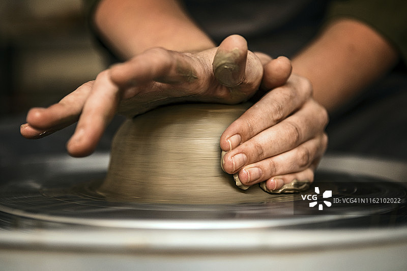 陶艺工匠在陶轮上用手塑造粘土图片素材