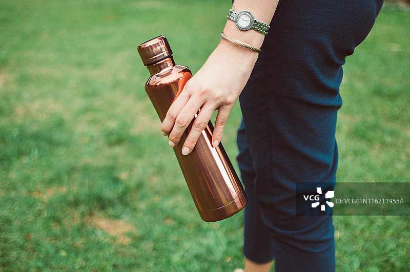 年轻女人拿着一个可重复使用的保温饮料容器图片素材