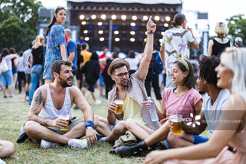 年轻的朋友在音乐节期间在草地上放松图片素材