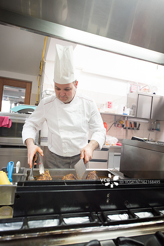 厨师在专业厨房烤肉图片素材