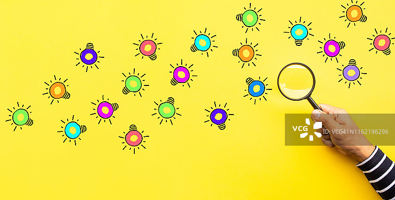 用放大镜寻找灯泡的创意灵感概念图片素材