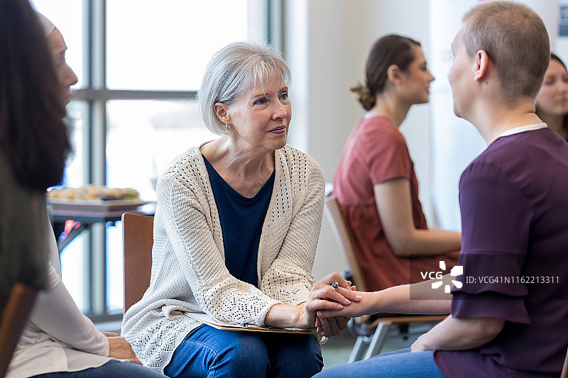 理疗师富有同情心地倾听患癌女性图片素材