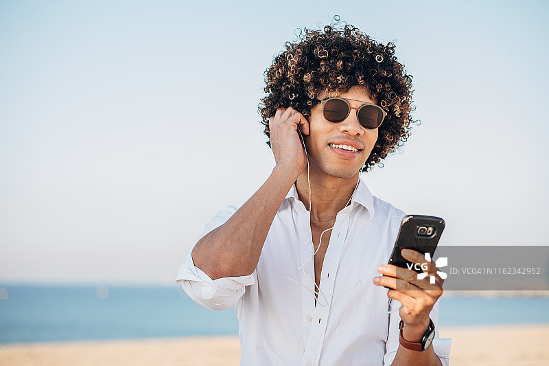 正在听音乐的迷人年轻人图片素材