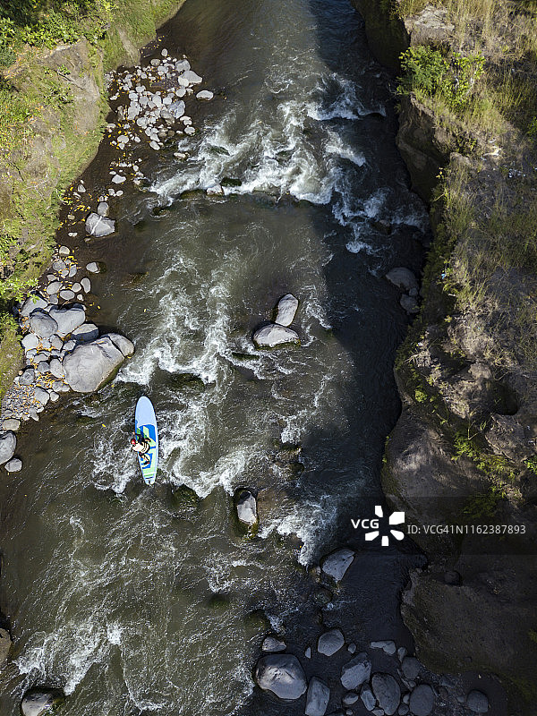 男人在河里划桨板图片素材