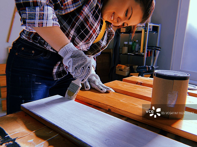 在车库里绘画木板的女人图片素材