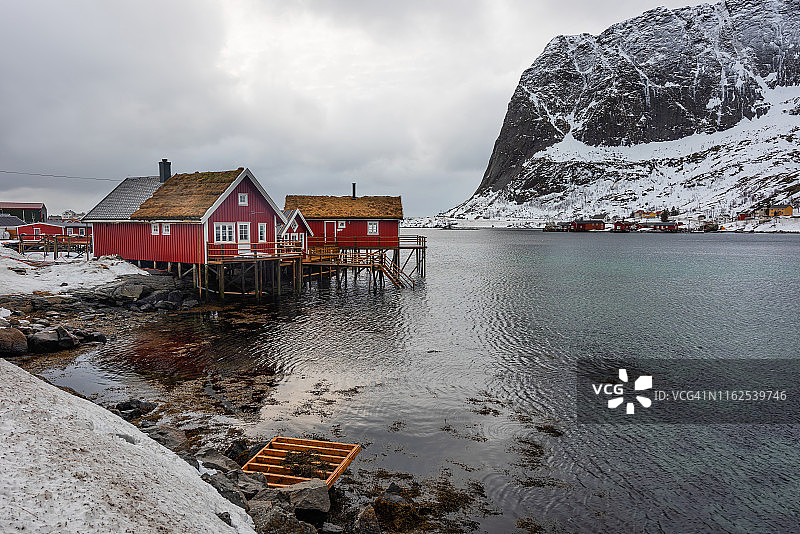 挪威萨克里索伊渔村日落时分的罗弗敦群岛冬季风光，传统黄色渔民小屋图片素材